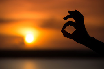 Ok hand sign silhouette at sunset
