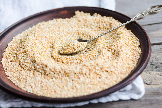 sesame seeds in a clay dish, a teaspoon of seeds,selective focus