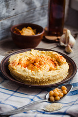 Hummus, chickpea dip, with smoked paprika in a clay plate