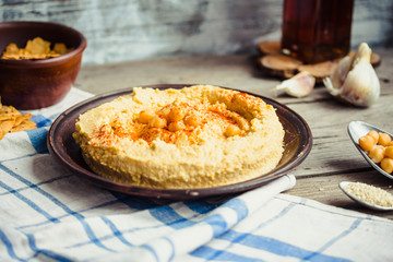 hummus of chickpeas, tahini paste and with paprika in a clay pla