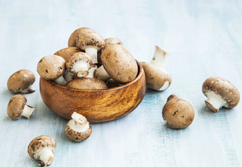 Fresh champignon mushrooms in a wooden bowl