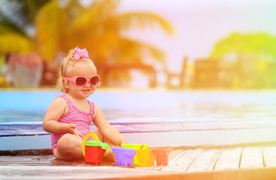 cute little girl playing in swimming pool at beach