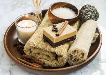 Spa-care products with coffee and cinnamon soap, towel and candl