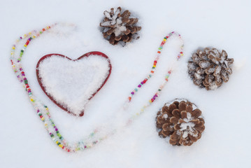 pine cones and heart in the snow