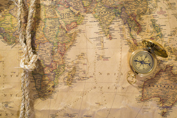 old compass and rope on vintage map