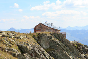 Fototapeta na wymiar Craftsmen standing on the roof of alpine hut Bonn Matreier Hütte in Hohe Tauern alps, Austria