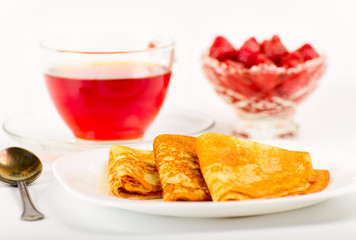 Russian pancakes with black tea and strawberries.