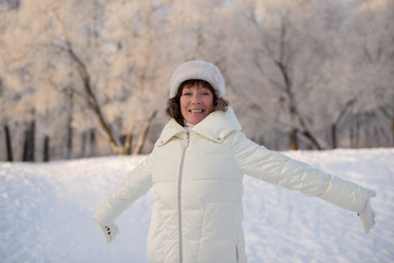 Fototapeta na wymiar Beautiful woman 50 years old walking on the snowy city of St. Petersburg