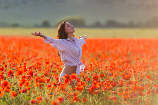 Girl at blooming poppy field