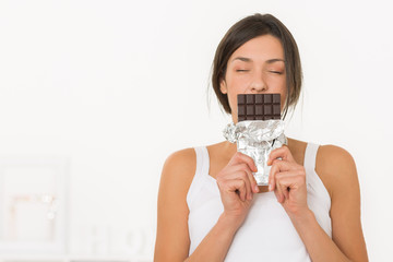Beautiful girl enjoying the smell of a dark chocolate