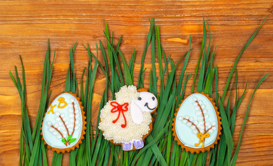Easter cookie. Little Sheep and Easter eggs on green grass