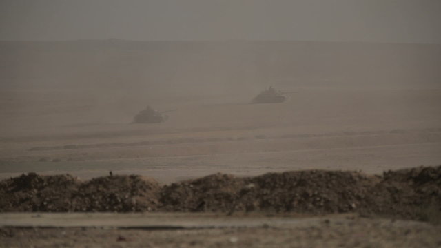 Tanks go on a desert before the fight.