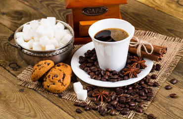 Cup and saucer filled with coffee beans and cane sugar