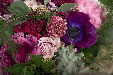 Obraz na płótnie Canvas Beautiful close-up of a flower arrangement with purple and pink roses, peonies, anemones and lilac flowers