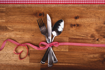 Valentines day set with silverware on wood background