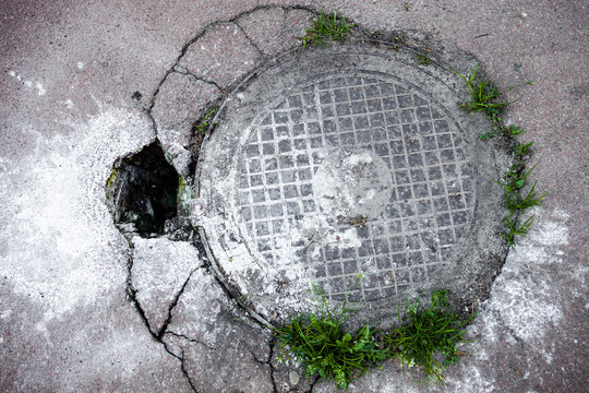 Manhole in cracked asphalt surface
