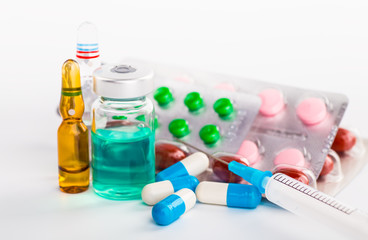 Pills in the flask, vials and the tubes with medications on whit