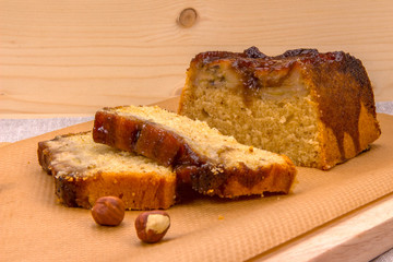 Homemade banana cake with hazelnuts on wooden board