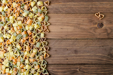 Pasta hearts on wooden background. Valentine's day background