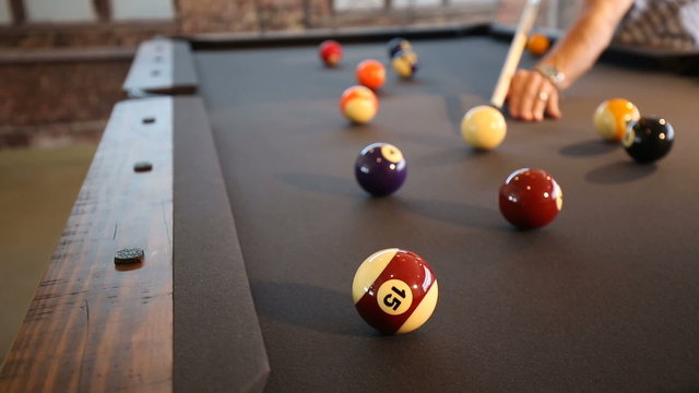 Pool Ball Hit in the Corner Pocket Lower. Two Shots. Camera lowers on player hitting the pool ball into the corner. One shot hits the ball in and next shot misses
