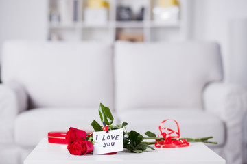 Red roses on the table with note I love you