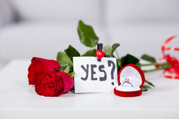 Fototapeta premium Red roses on the table with proposal note yes
