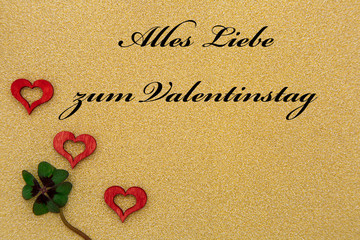 drei Herzen und ein Kleeblatt mit Text auf goldenem Hintergrund