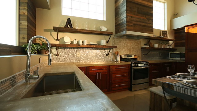 Modern Kitchen Dolly Right and Sun Flare Through Window. camera moves right on a modern kitchen. Sun flare coming through large windows showing all details of the kitchen and from the sink
