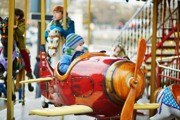 Boy taking a ride in plane on merry-go-round