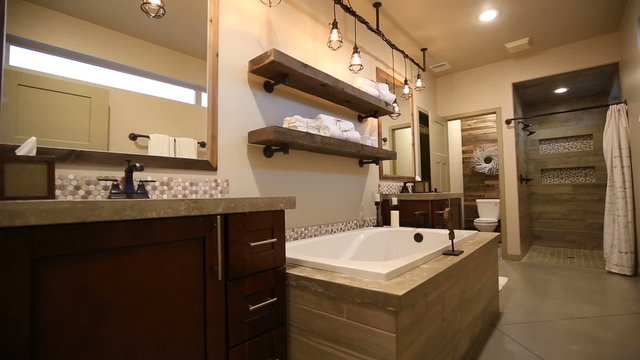 Modern Master Bathroom Rise Up from Floor. Two shots. camera rises from a low angle shot of a modern bathroom to reveal double sinks, tub, stand up shower and toilet room. Shot of close up shower
