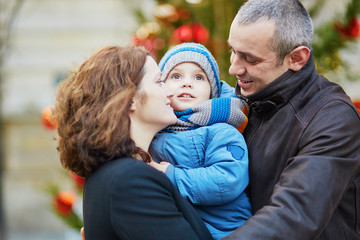 Happy family of three walking together in Paris