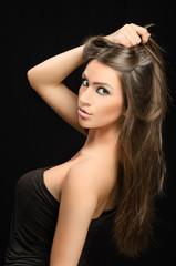 Naklejka premium Beauty shot of nice dark haired woman on black background
