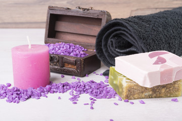 spa background. towel, candle, soap, violet sand in a chest