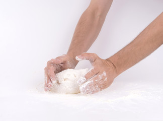 Kneading dough; close-up of male hands in flour kneading dough
