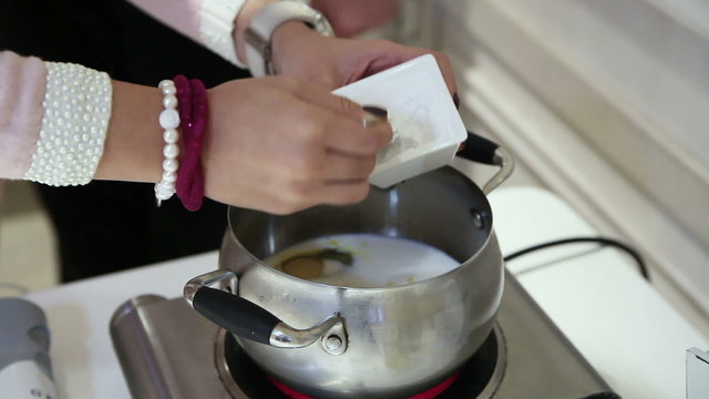 Chef pours starch in a pan. Close-up