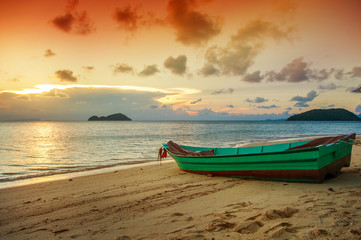Boat on the beach against the backdrop of a beautiful sunset. Th