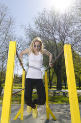 Young woman exercise on parallel bar, outdoor.