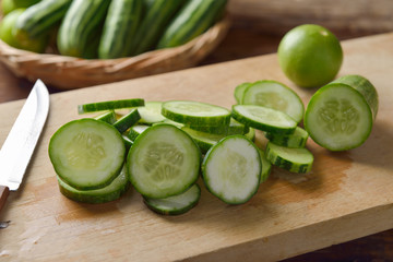 Fresh cucumber and slices on the wooden table