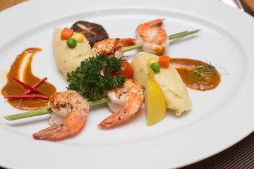 A steak shrimp with  fresh with fresh vegetables on a white plat