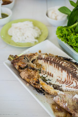 Closeup of salt grilled fish with spicy Thai dressing salad