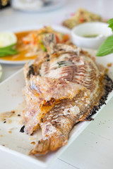 Closeup of salt grilled fish with spicy Thai dressing salad