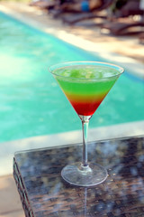 Cocktail on swimming pool background