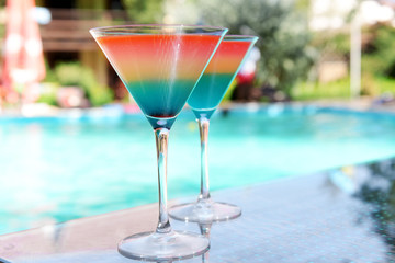 Cocktails on swimming pool background