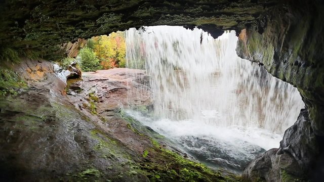 Loop features a view from beneath a waterfall in autumn. O Kun de Kun Falls, is located in the western Upper Peninsula of Michigan.