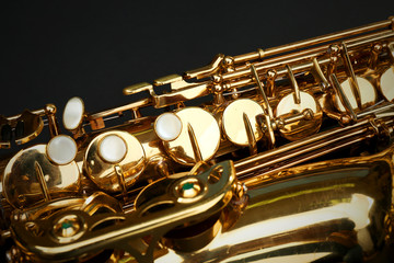 Obraz premium Beautiful golden saxophone on black background, close up