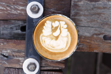 cup of latte art coffee on wooden background