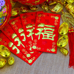 Chinese new year ornament on gunny sack, red envelope with Chinese letter "FU" meaning meaning "fortune" or "good luck, gold ingot, Chinese lamp