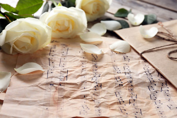 Beautiful rose on music sheets background