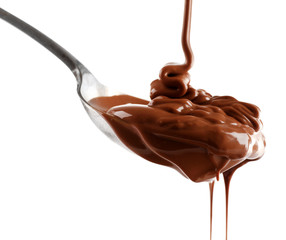 Melted milk chocolate pouring from a spoon, isolated on white