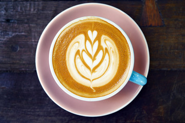 cup of latte art coffee on wooden background